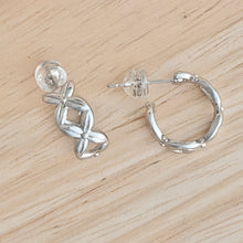 Load image into Gallery viewer, Dainty silver hoop earrings feature an X pattern. Small and subtle these hoops are good for every day wear