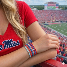 Load image into Gallery viewer, Ole Miss fan wearing red and blue bracelets at the Mississippi football stadium for game day