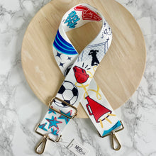 Load image into Gallery viewer, Adjustable bag strap with a collage of soccer themed graphics in support of the Kansas City Current women's team. Gold hardware and buckles