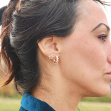 Load image into Gallery viewer, Woman wearing star-shaped earrings with a blurred natural background