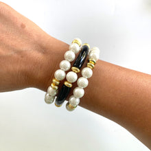 Load image into Gallery viewer, Black pearl bracelet stacked with gold bracelets
