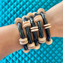Load image into Gallery viewer, Stack of black acrylic and brown wooden bead bracelets are a statement for any wrist
