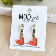 Heart-shaped earrings on a 'MOD+ish Design Co' card with green leaves in the background.
