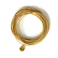 Gold stackable spring bracelets set on wrist