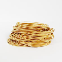 Load image into Gallery viewer, Gold stainless steel spring bracelets stacked on wrist everyday style
