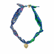 Colorful patterned neck scarf with a gold heart pendant on a white background