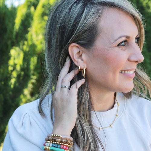 Woman wearing colorful bracelets and earrings outdoors