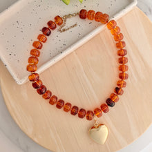 Load image into Gallery viewer, Chunky honey brown beaded necklace is perfect to add a pop of color to your fall outfit.  The gold heart charm is removable allowing 2 different looks
