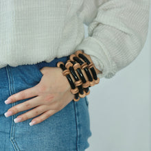 Load image into Gallery viewer, Stack of black and brown wooden bead bracelets create a polished look
