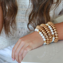 Load image into Gallery viewer, Pearl stretch bracelet layered with gold bracelets
