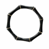 Black acrylic bracelet stacked with gold bracelets