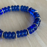 cobalt blue glass rondelle beads separated by gold discs on a stretch bracelet